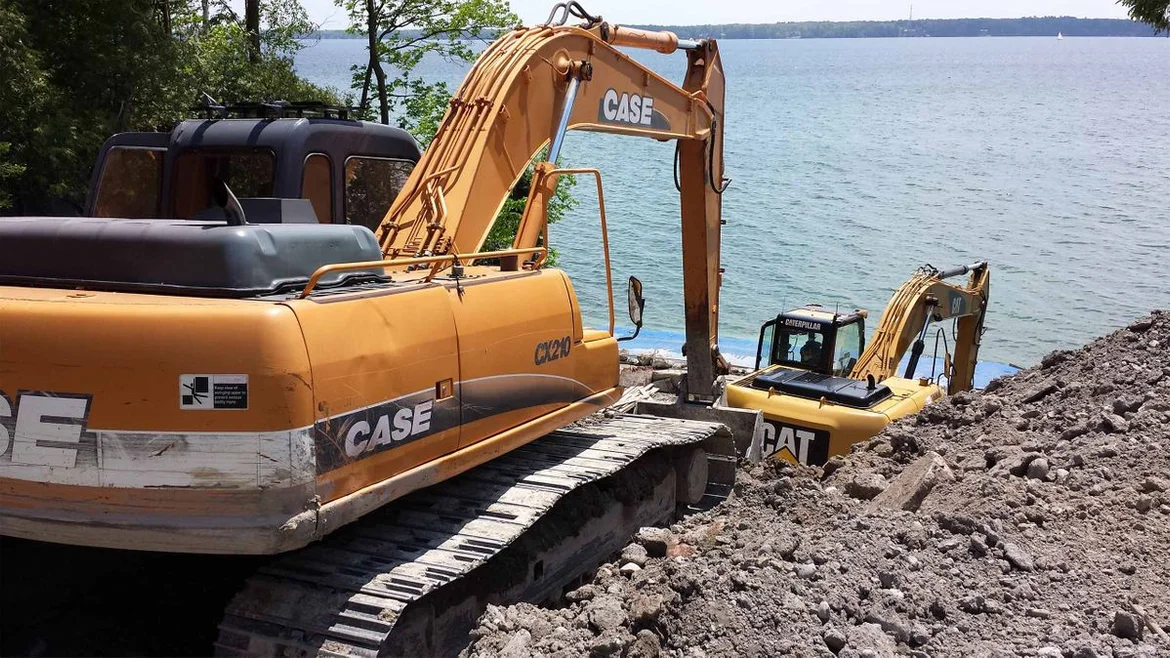 Excavators near a lake